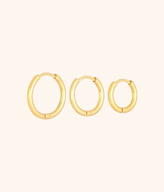 goldene Ohrringe in rundem Design vor weißem Hintergrund abgebildet in drei verschieden größen