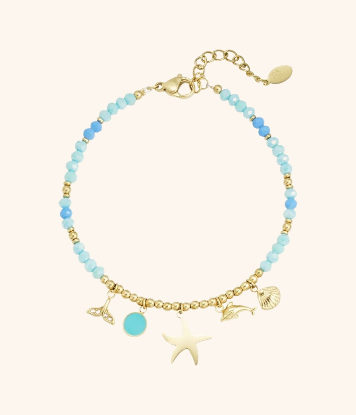 goldenes Armband mit blauen Steinen und Anhängern in verschiedenen Formen vor weißem Hintergrund