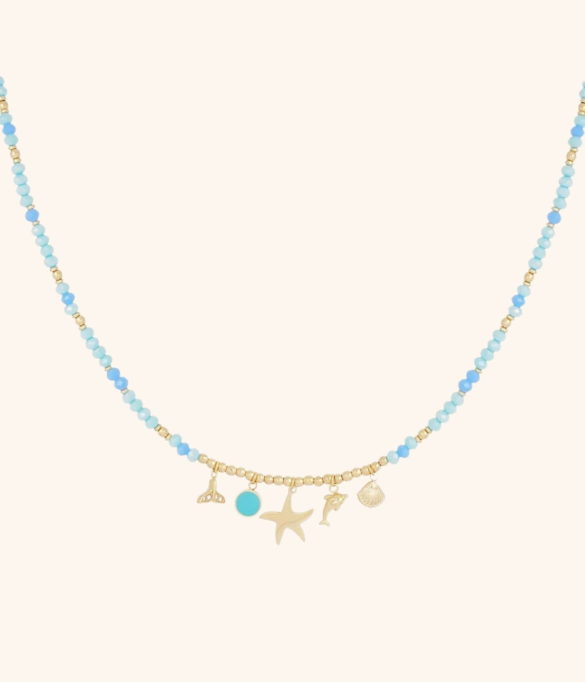 goldene Kette mit blauen Steinen und Anhängern in verschiedenen Formen vor weißem Hintergrund