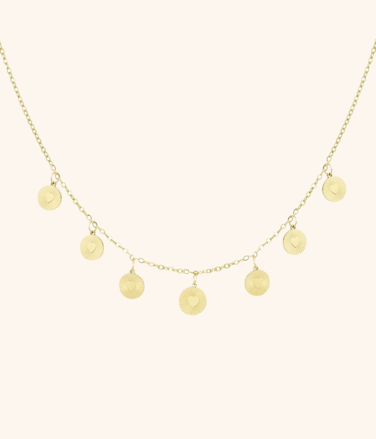 goldene Kette mit Plättchenanhängern vor weißem Hintergrund