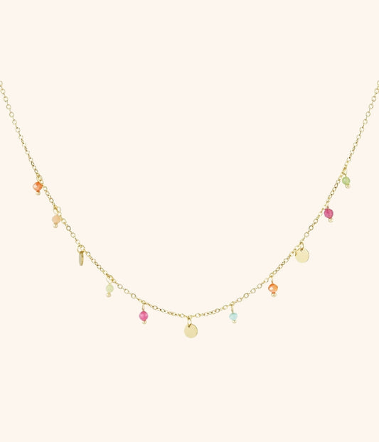 goldene Plättchenkette mit Anhängern bestehend aus bunten steinen und goldenen Plättchen, vor weißem Hintergrund