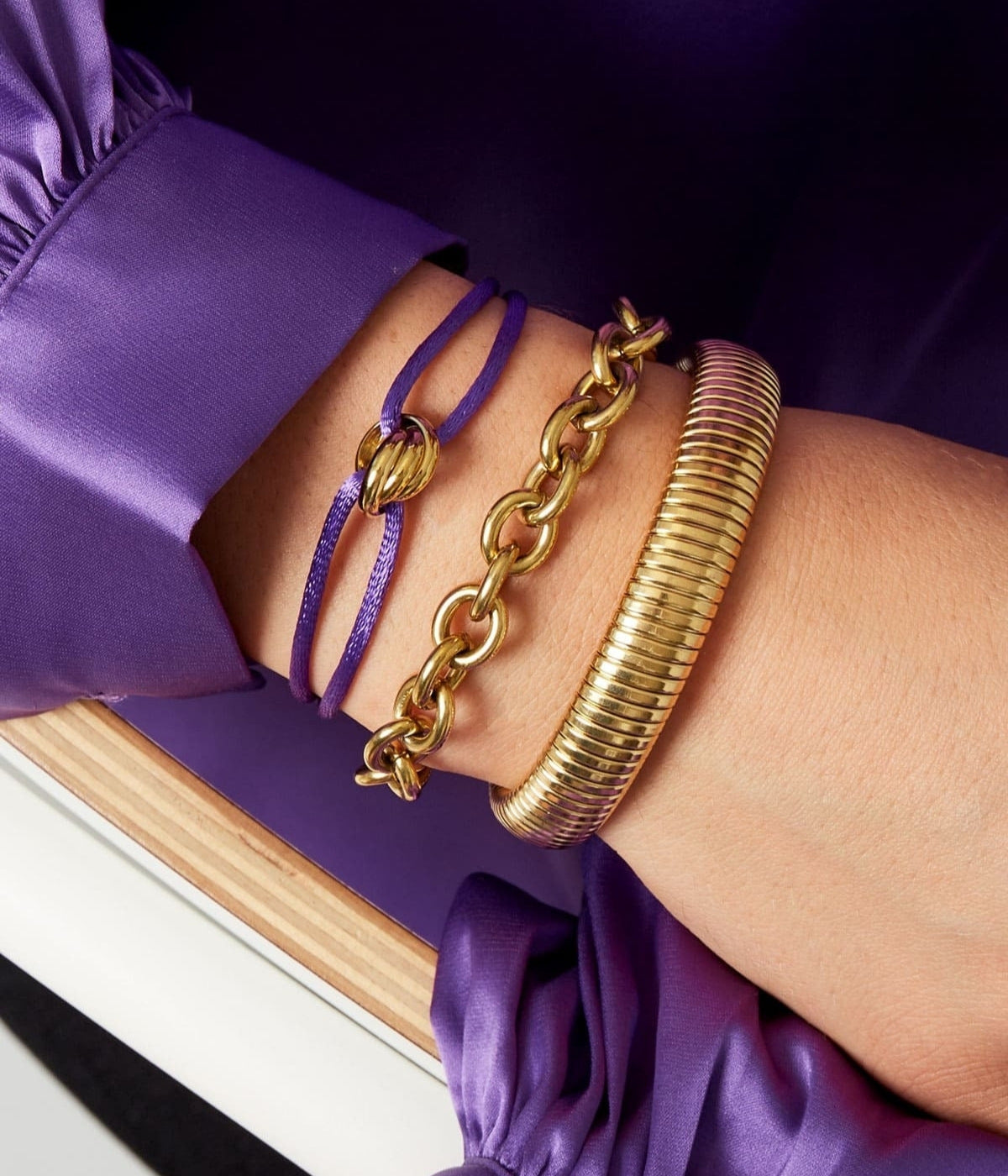 Lila Satin Armband mit goldenem Knoten getragen an einem Arm