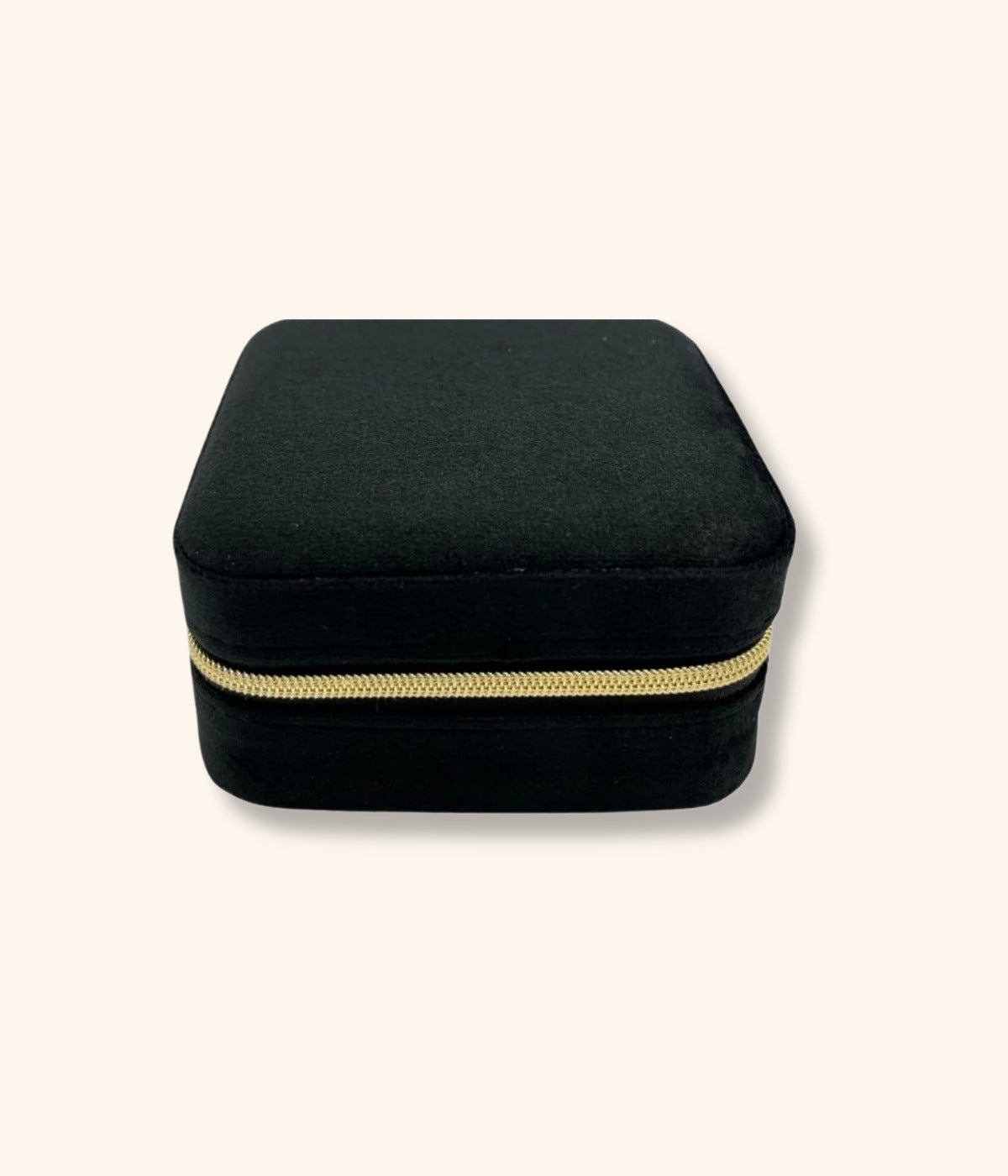 Kleine quadratische Tasche zur Schmuckaufbewahrung. Tasche ist in schwarzem Velourstoff und goldenem Reisverschluss. Die Schmucktasche liegt auf weißem Hintergrund