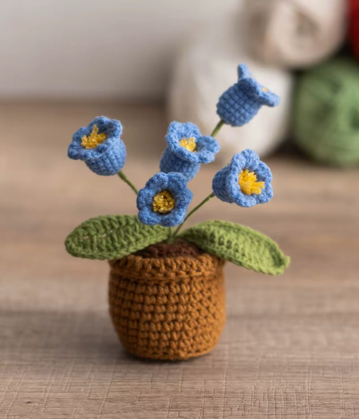 Gehäkelte blaue Glöckchenblumen im Topf – farbenfrohe Blume aus Wolle