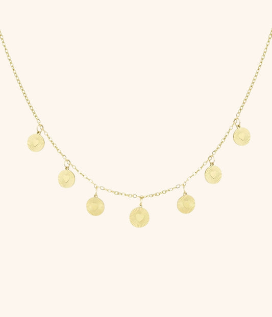 goldene Kette mit Plättchenanhängern vor weißem Hintergrund